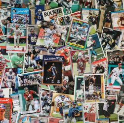 A collection of various sports trading cards spread out on a flat surface.