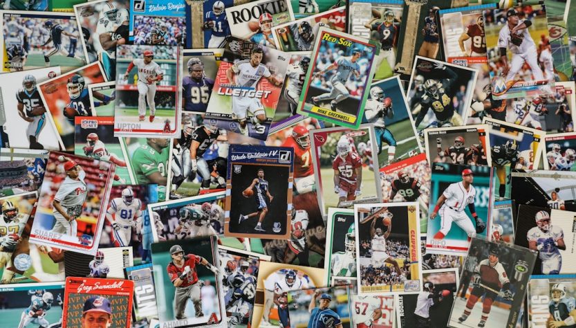 A collection of various sports trading cards spread out on a flat surface.